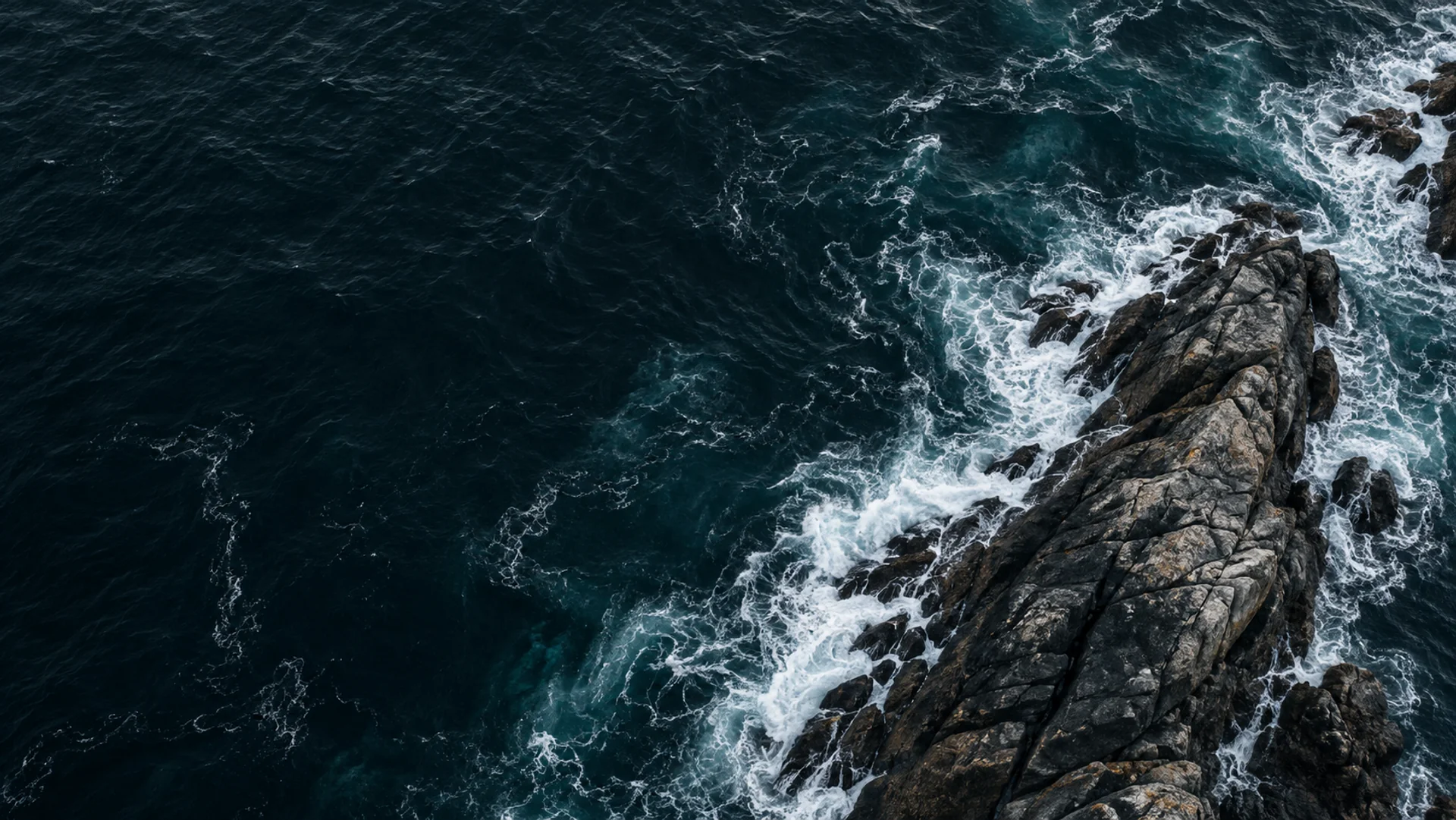 Imagen conceptual de una costa atlántica: mar azul profundo, granito y una curva de espuma.